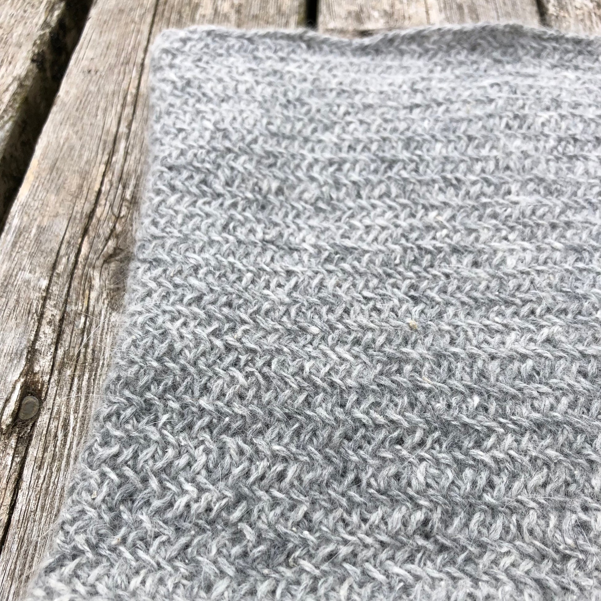 Up close shot of the grey ramie/acrylic/angora yarn and the stitches of this neck warmer.